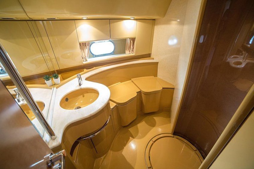 Un baño moderno y compacto con lavamanos, inodoro y tocador. 2