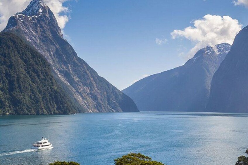 A boat on a calm lake surrounded by mountains. 3