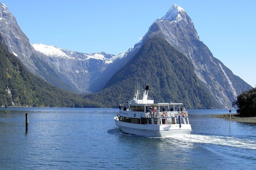 A boat on a lake with mountains in the background. 2