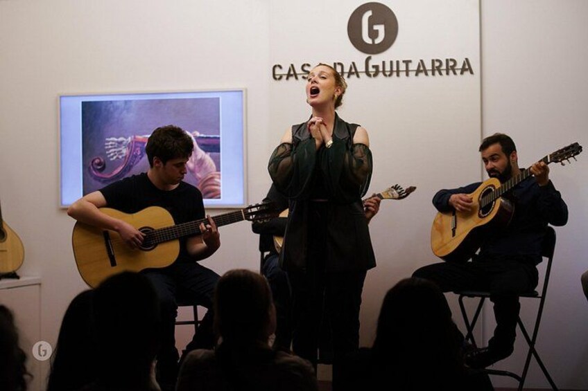 Una presentación musical con tres guitarristas y una cantante en el escenario. 4