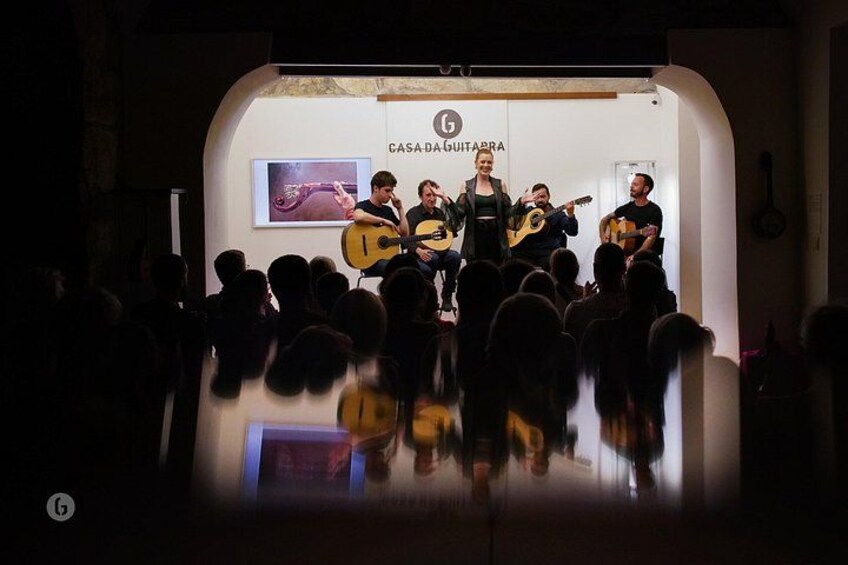 Una banda tocando en el escenario con un logo 'CASADA GUITARRA' al fondo. 2