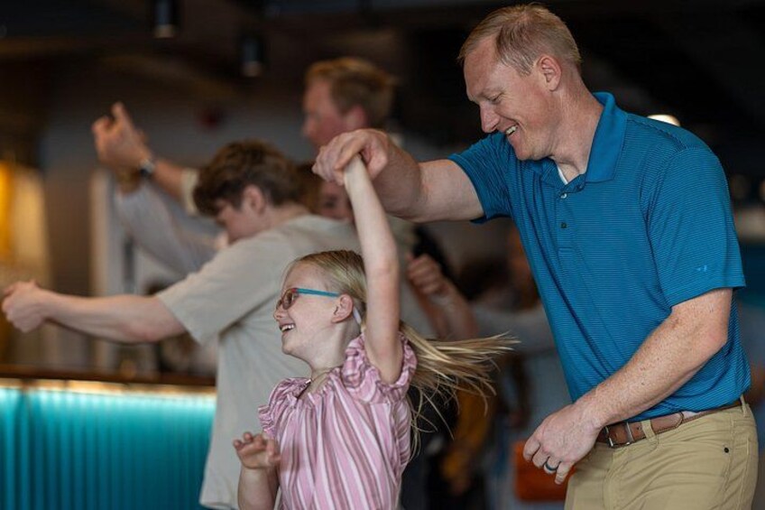 A person in a blue shirt dancing with another person in a pink striped shirt. 4