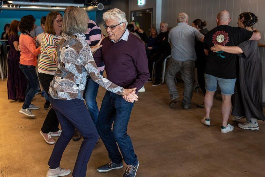A group of people dancing in a room. 1