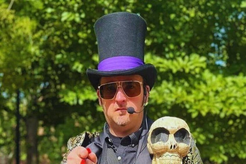 A person wearing a top hat and holding a skull. 4