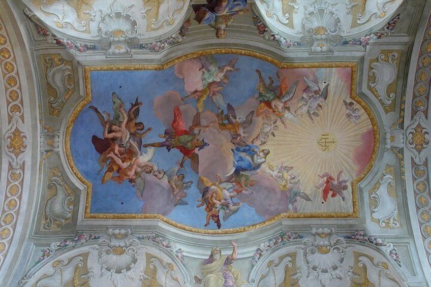 A ceiling with elaborate frescoes and gold accents. 1