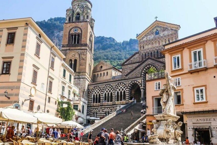 Una plaza histórica con una iglesia, un campanario y una fuente. 2