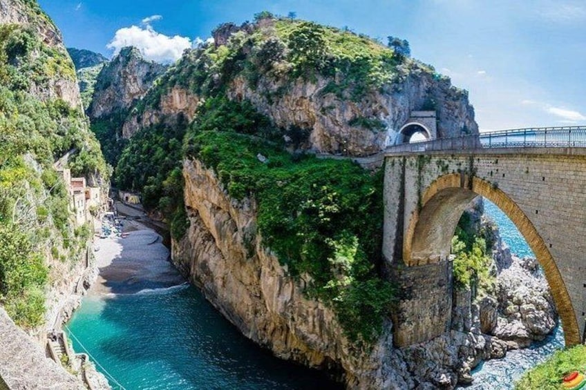 Un paisaje costero con un puente, acantilados y una playa. 4