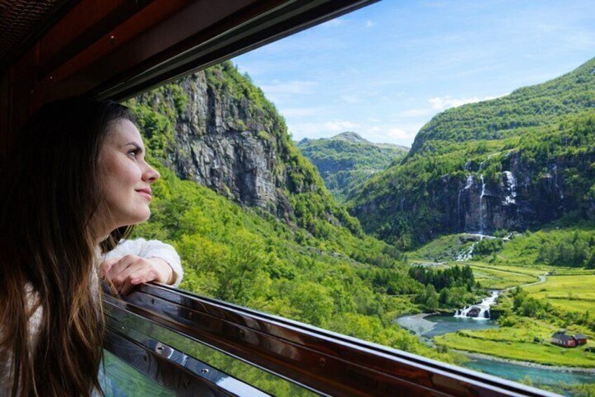 Una persona contemplando un paisaje montañoso con un río y cascadas. 4