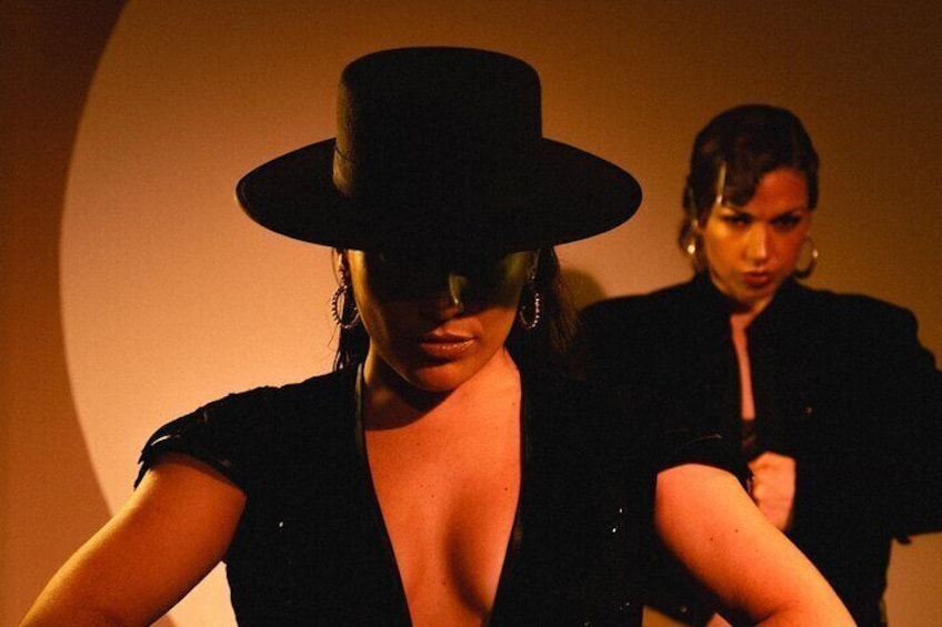 A person wearing a black hat and a black dress with a deep neckline. 3