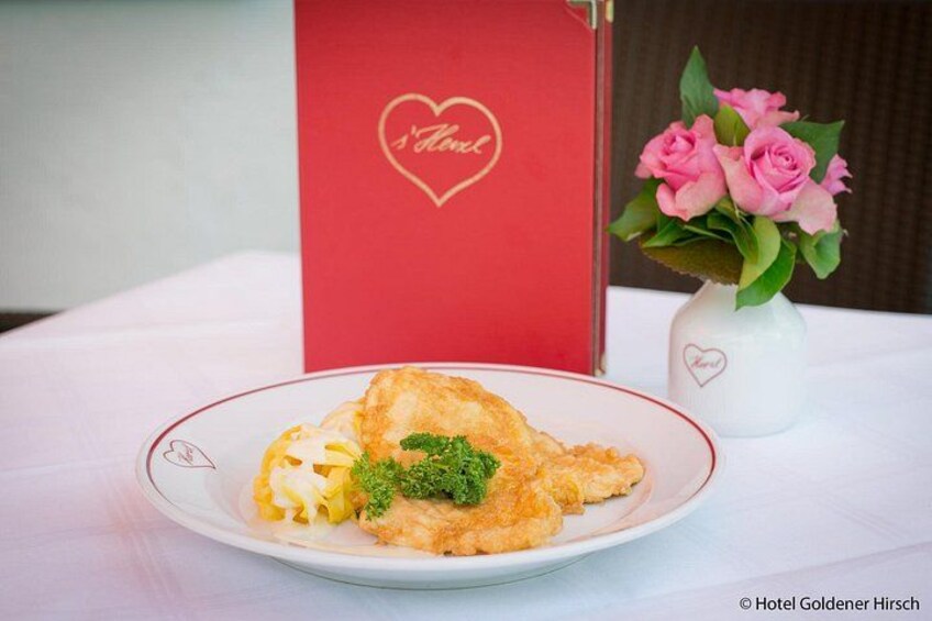 A plate of food with a heart-shaped decoration, a red sign with a heart, and a vase with pink flowers. 5
