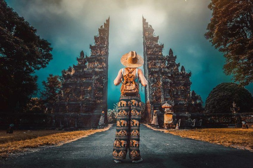 A person in traditional attire walking towards a temple with intricate architecture. 2