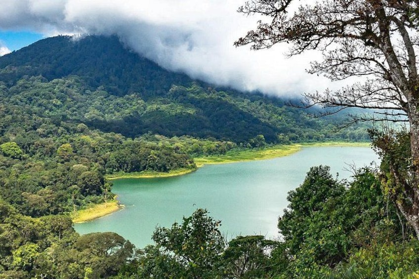 A lake surrounded by dense forest and a mountain. 2