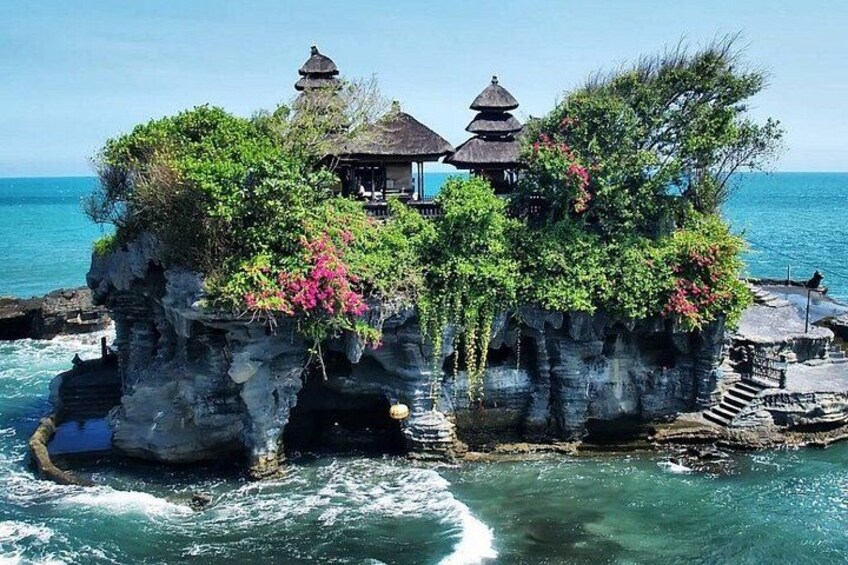 A traditional Balinese temple on a rocky outcrop surrounded by ocean waves. 3