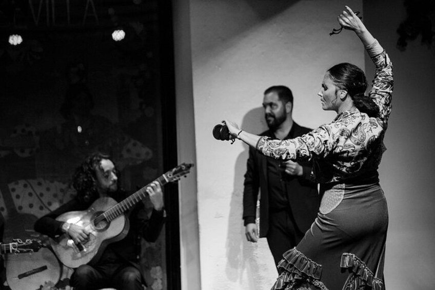 A person playing a guitar and another person gesturing. 3