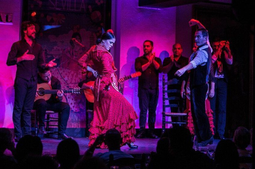 Un spectacle sur scène avec des musiciens et une chanteuse, une robe rouge et une guitare. 3