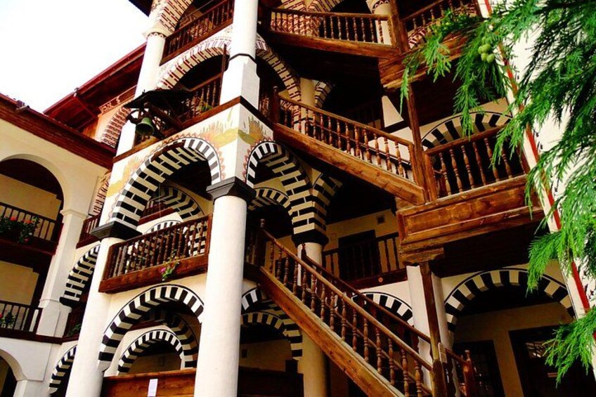 A multi-story building with wooden balconies and arches. 5