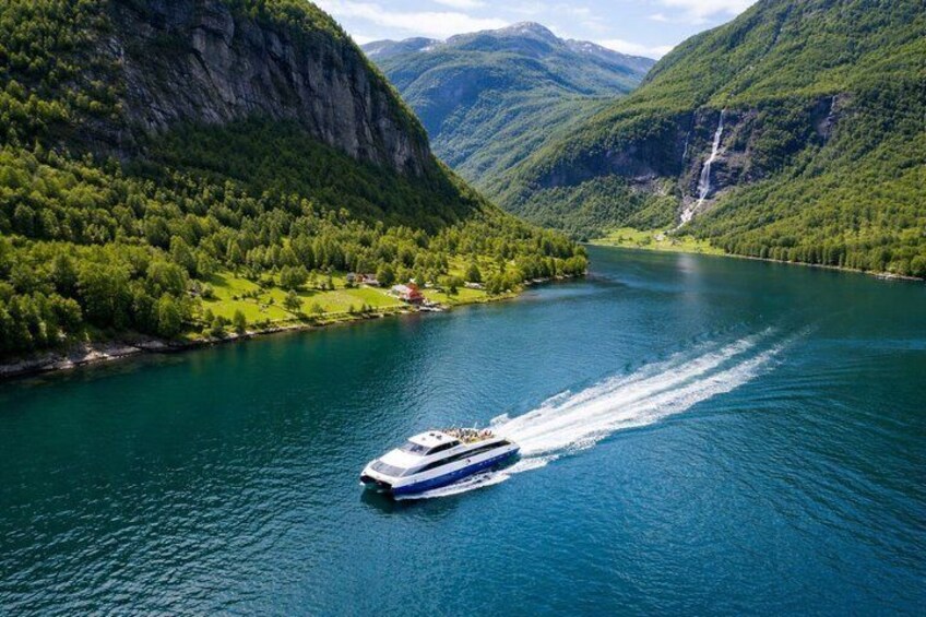 A boat traveling on a river surrounded by mountains and greenery. 3