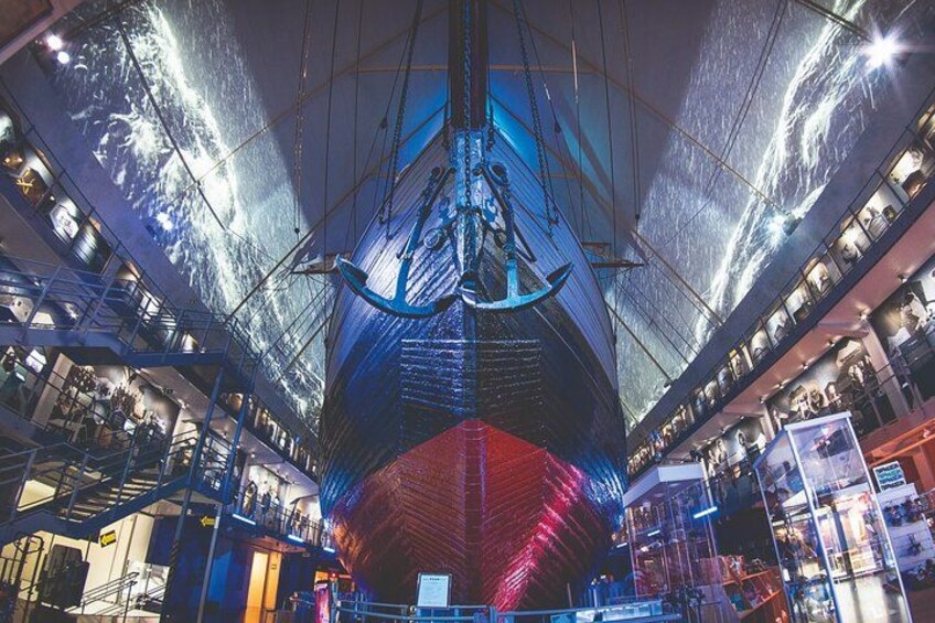 A large ship's hull inside a building with a digital projection of a ship's bow on the ceiling. 1