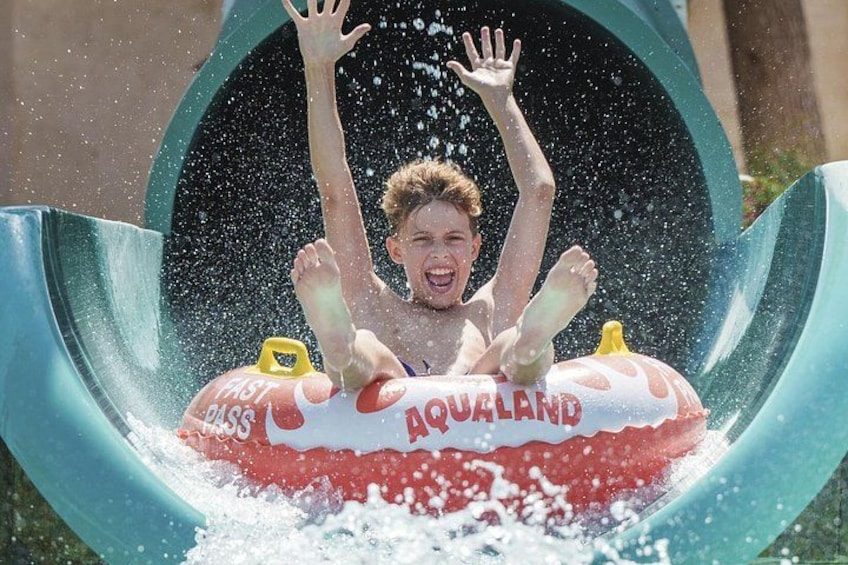 A person sliding down a water slide with a tube labeled 'AQUALAND'. 2