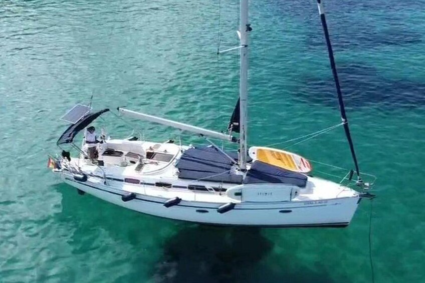A white sailboat with a cabin, a mast, and a solar panel on the deck. 1
