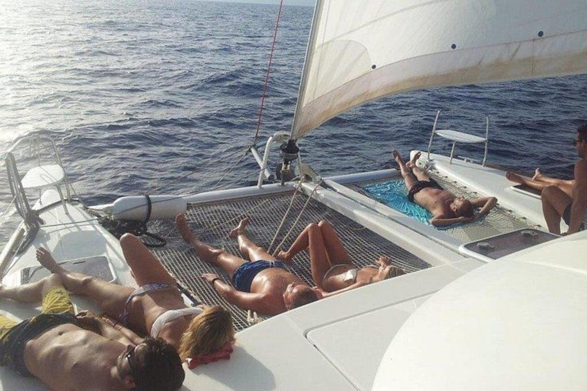 Een zeilboot met mensen die op het dek zonnen. 4