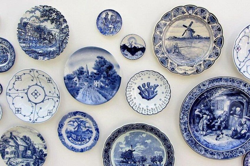 A collection of blue and white ceramic plates with various designs, including landscapes and figures. 5