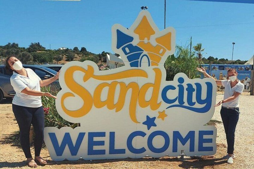 A large welcome sign with the text 'Sand city' and 'WELCOME' in a desert setting. 5