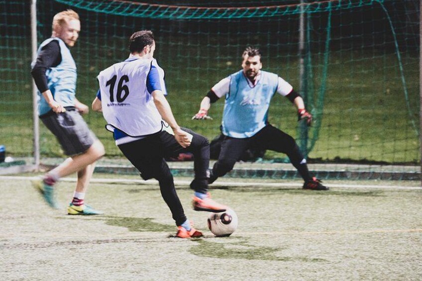 A soccer match with players in action, a goalpost, and a net. 2