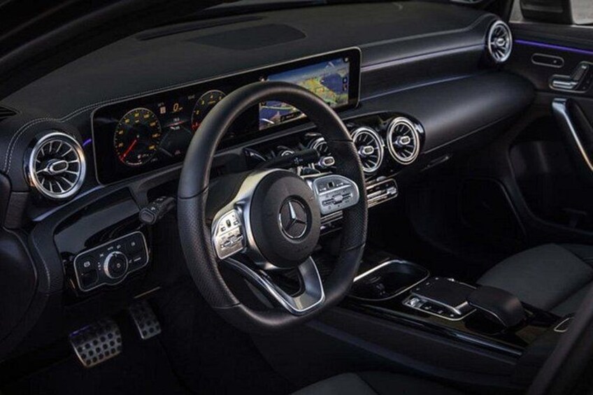 A luxury car interior with a steering wheel, dashboard, and center console. 5