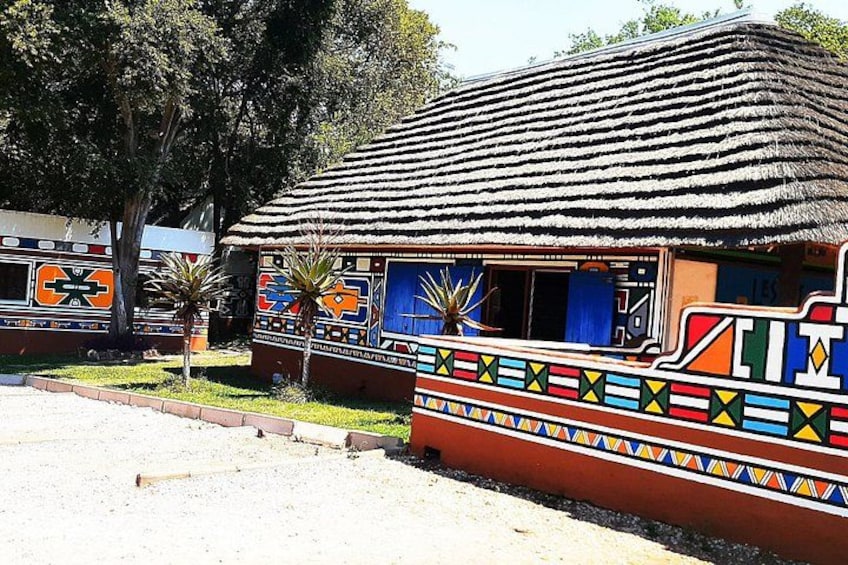 A traditional hut with colorful patterns and a thatched roof. 2