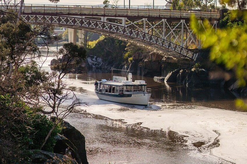 A river with a boat, a bridge, and rocky outcrops. 2
