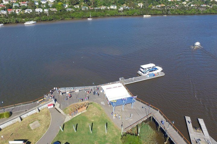 A river with boats, a dock, and a grassy area with people. 3