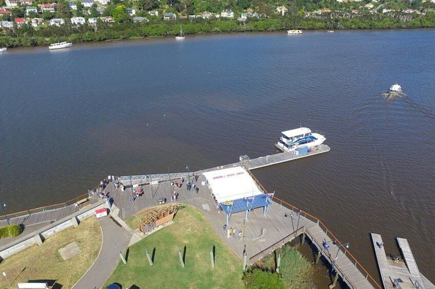 A river with boats, a dock, and a grassy area with people. 4