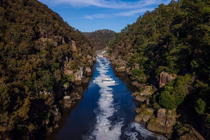 A river winding through a forested valley with rocky outcrops and dense greenery. 1