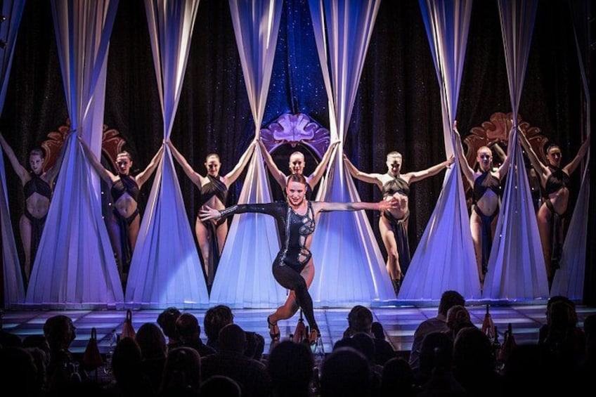 A ballet performance on stage with dancers in black costumes. 2