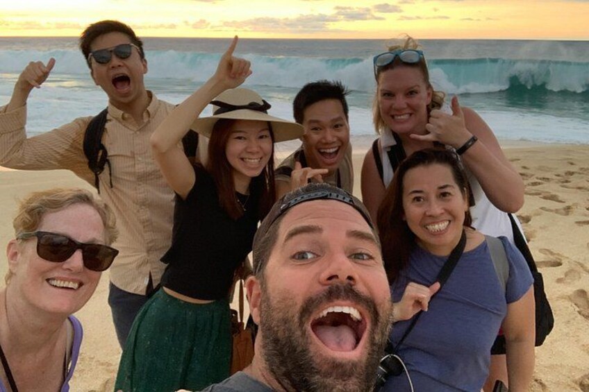Eine Gruppe Menschen am Strand, im Hintergrund Wellen. 5