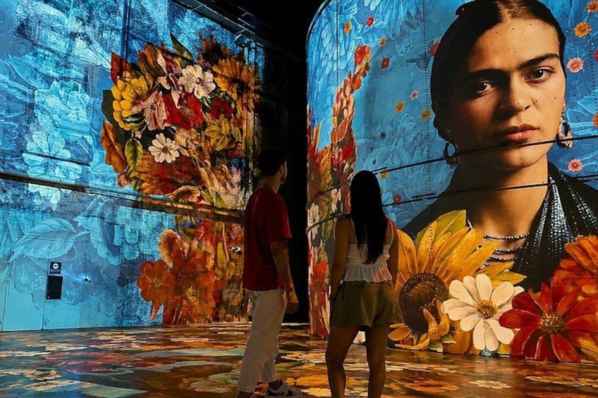 A mural with large floral patterns and a person standing in front of it. 5