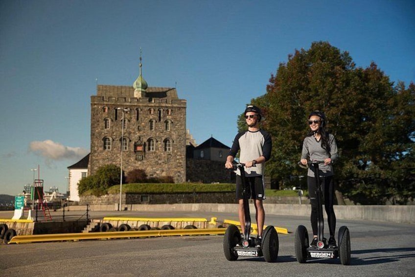 Two people on Segway hoverboards in front of a historic building. 5