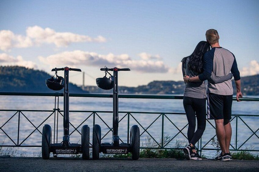 A couple standing by a waterfront with two stationary bikes. 3
