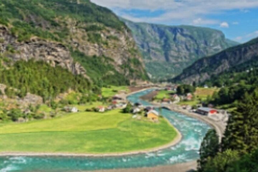 A river winding through a valley with houses and greenery. 3