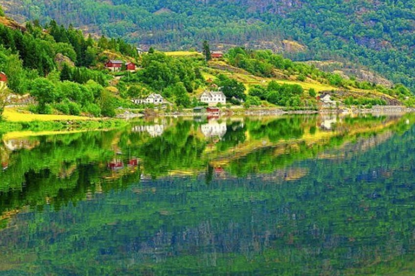 A lake with houses on the shore, surrounded by greenery and hills. 5