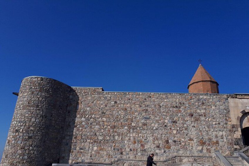 Un muro de piedra con una torre redonda y un techo cónico. 5