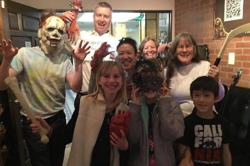 A group of people in a room with a brick wall and a door. 1