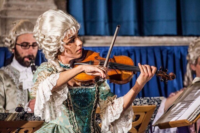 Una persona suona il violino con abiti d'epoca. 5