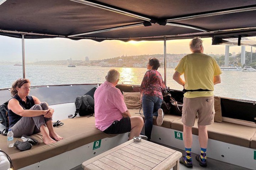People on a boat with a cityscape and bridge in the background. 4