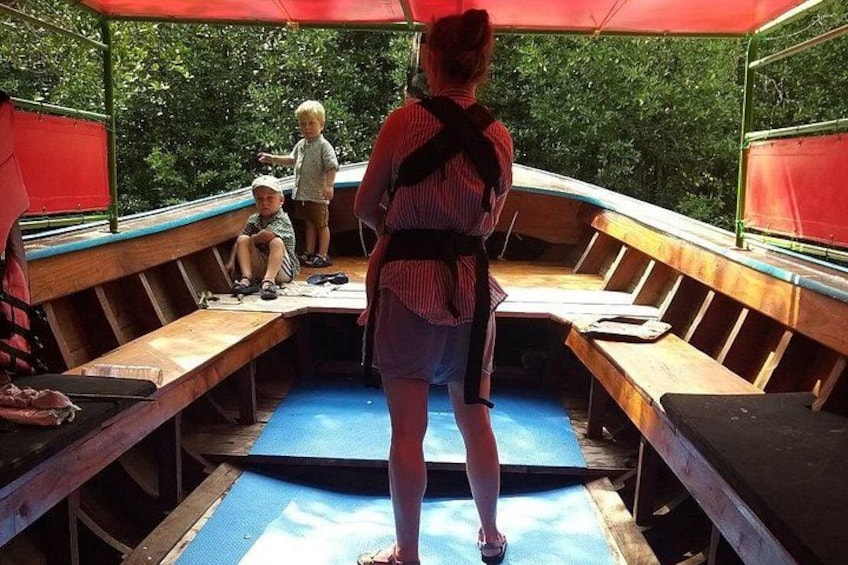 Un bateau avec des bancs en bois et une personne debout à la proue. 5