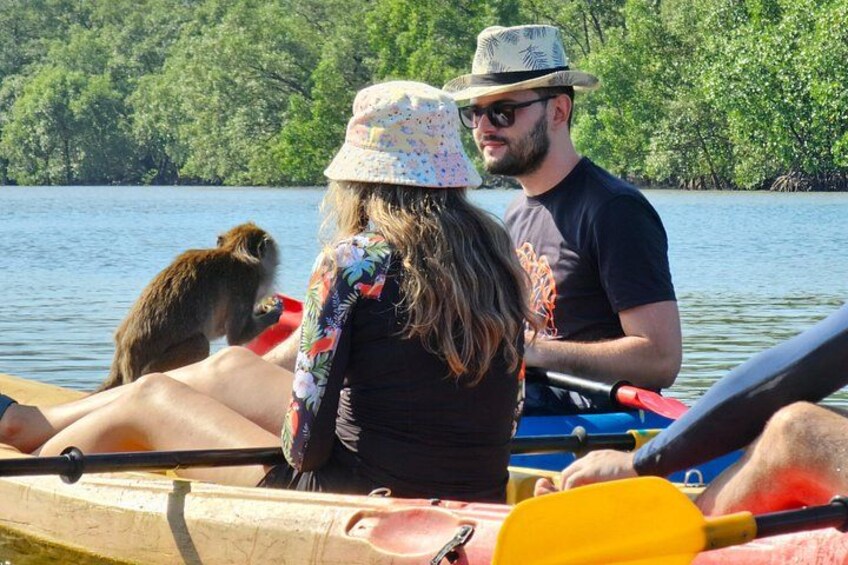 A group of people in a canoe on a calm lake surrounded by trees. 4