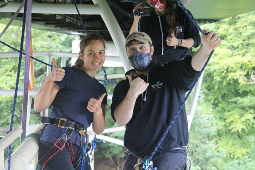 People engaged in a zip-lining activity with safety harnesses and ropes. 3