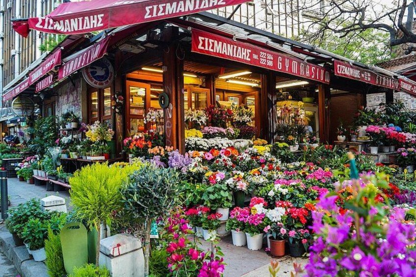 A flower shop with a variety of colorful flowers displayed outside. 2