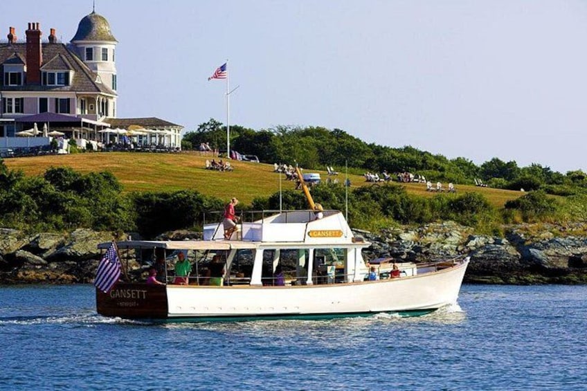 A boat named 'GRACIE' on water with a house and flag in the background. 2